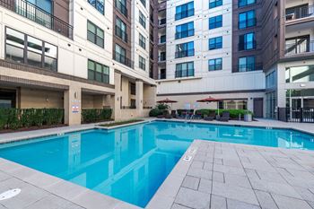 A large swimming pool in front of apartment buildings